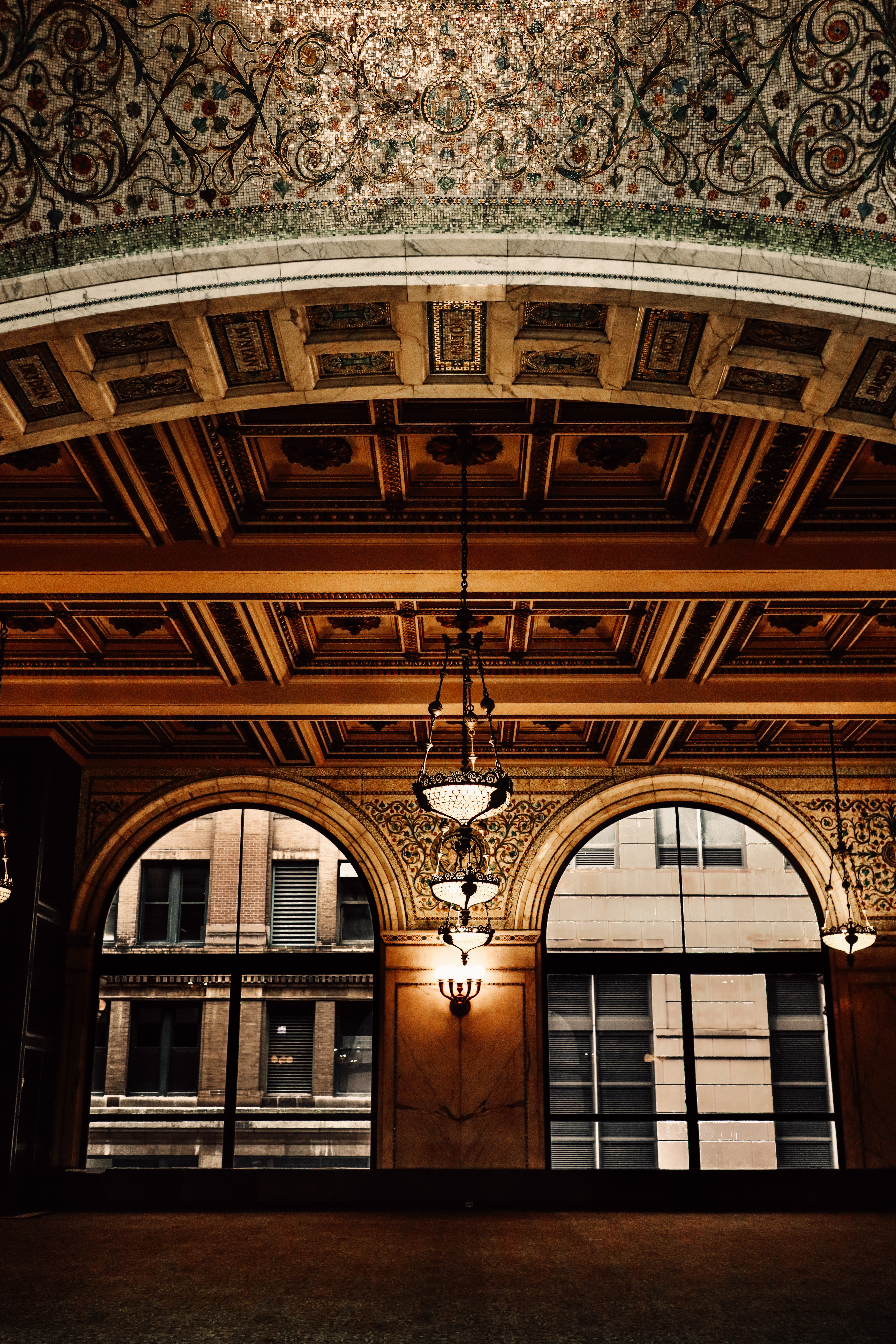 Chicago Cultural Center golden arcade — ornate arched openings look out to the street, warm light