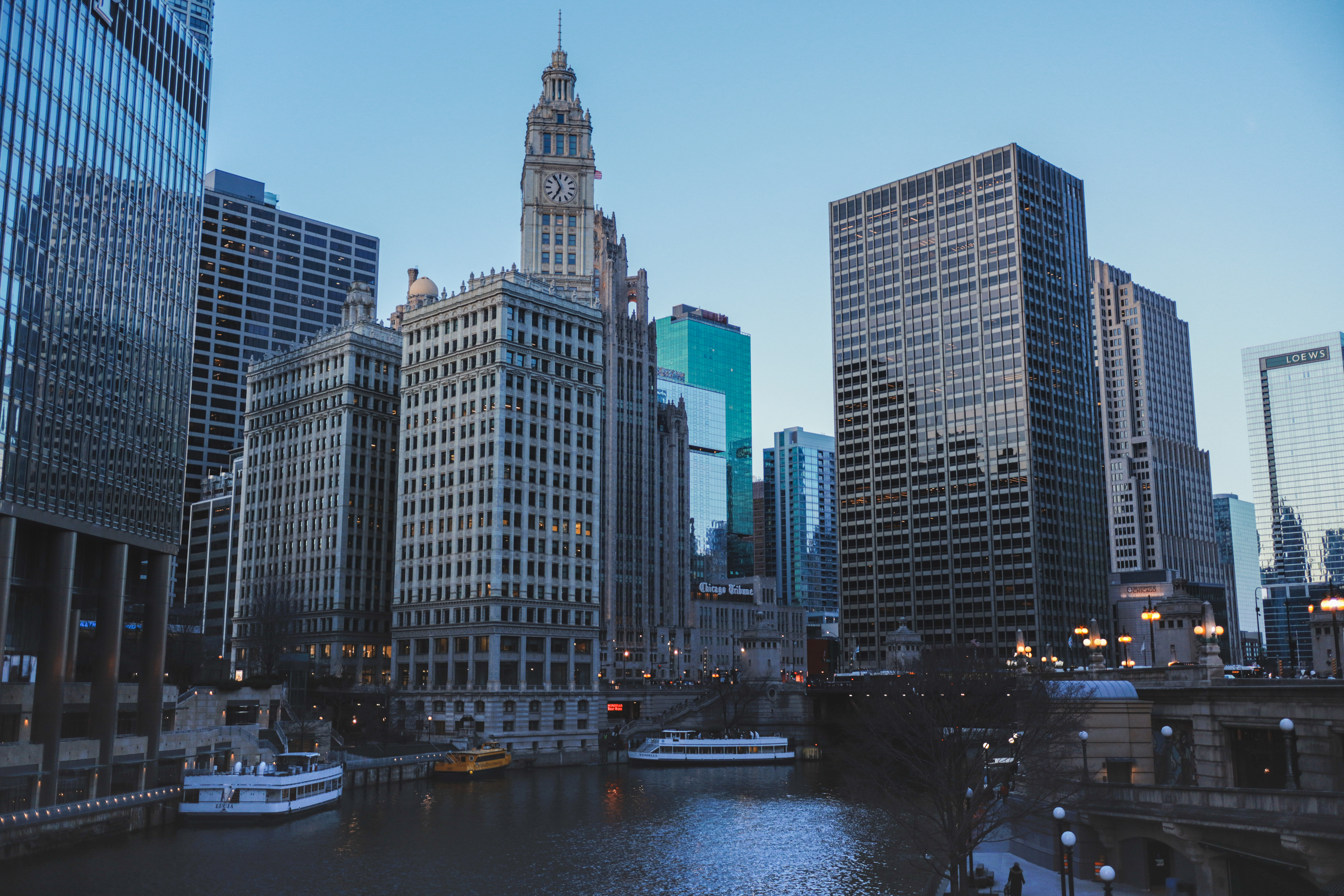 Chicago River at blue hour — tour boats docked, Wrigley Building and Tribune Tower lit