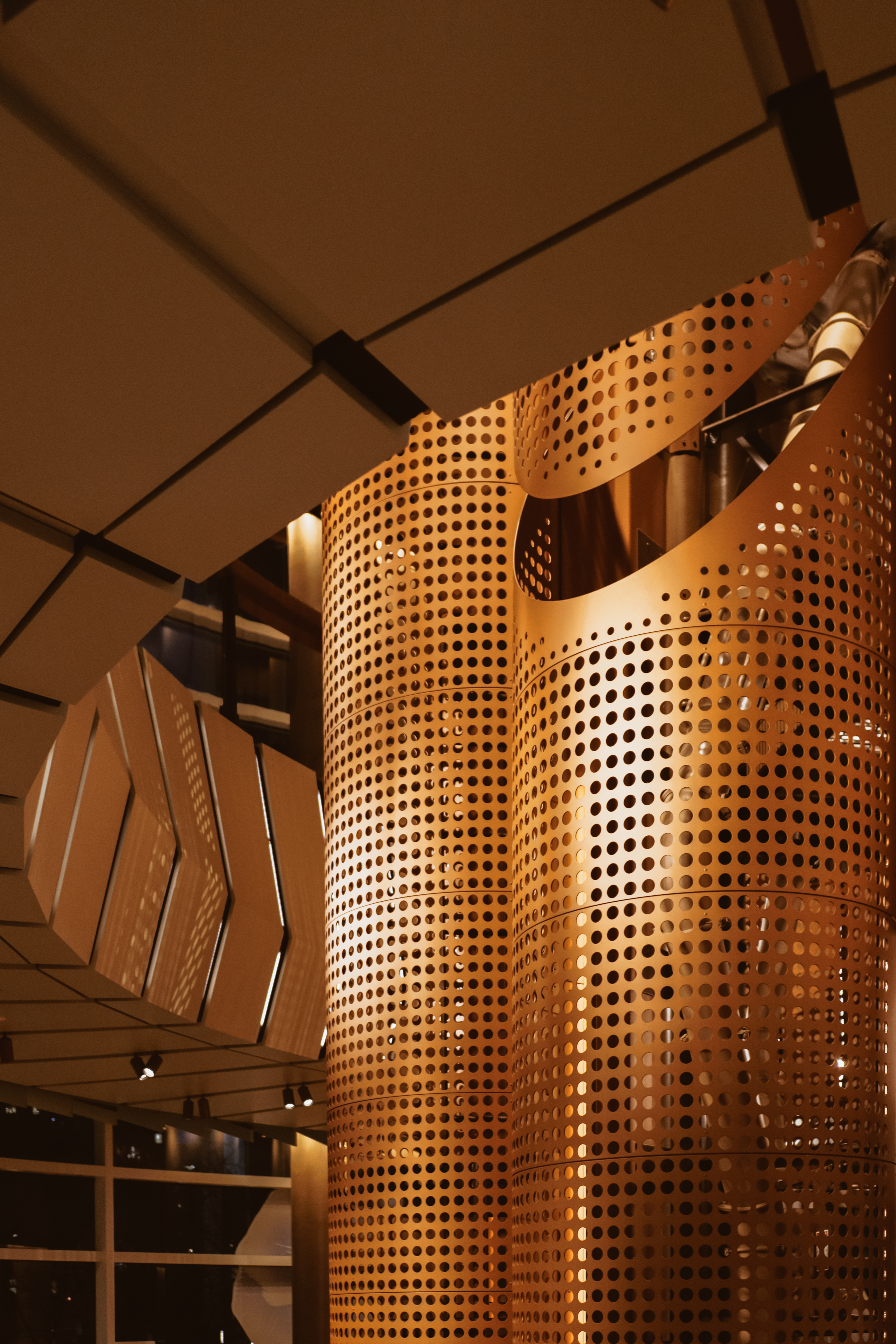 Starbucks Reserve Roastery — perforated copper cask close-up, warm amber light