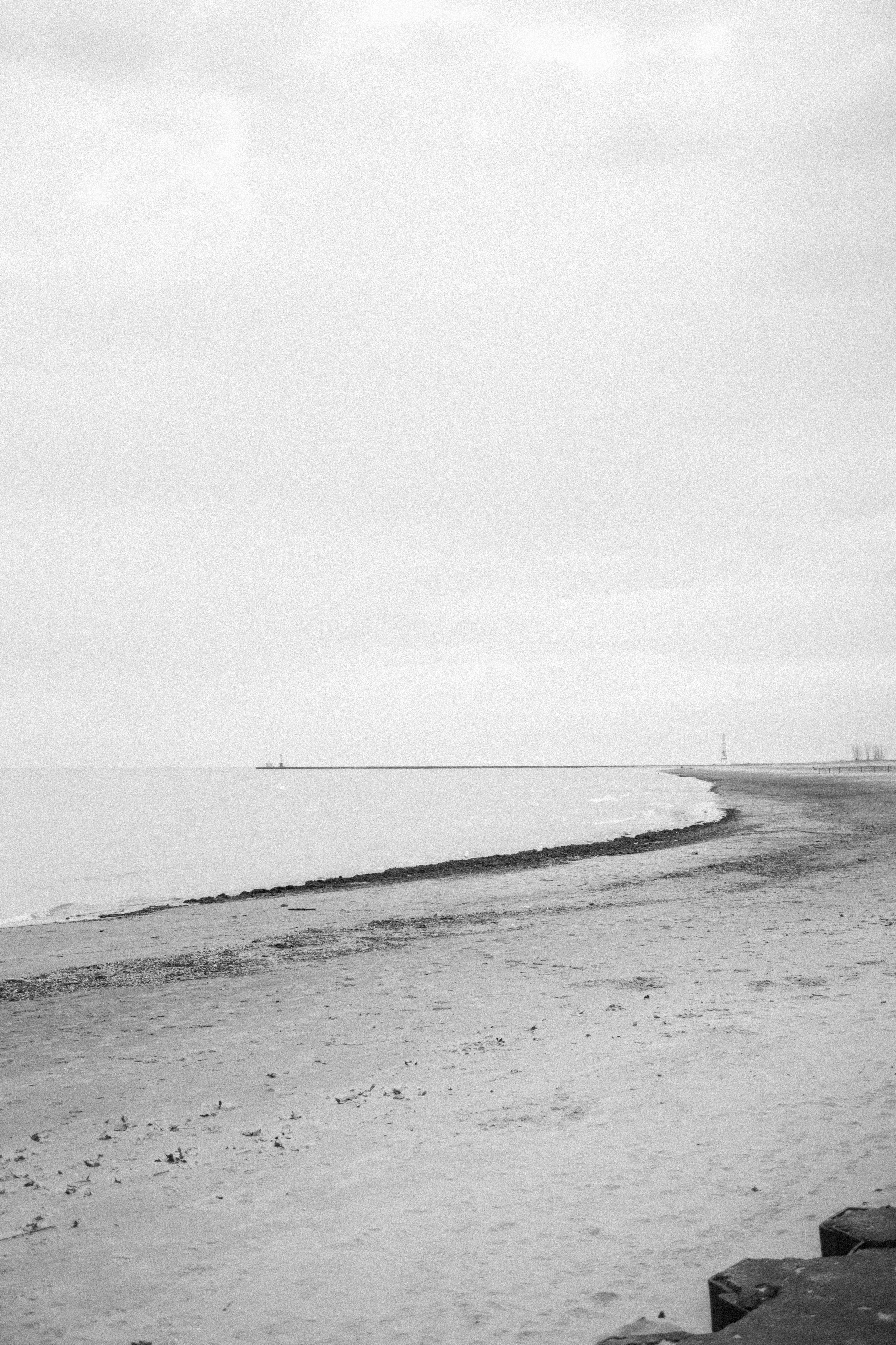 Lake Michigan at Montrose Beach in black and white — almost empty shore, distant lighthouse