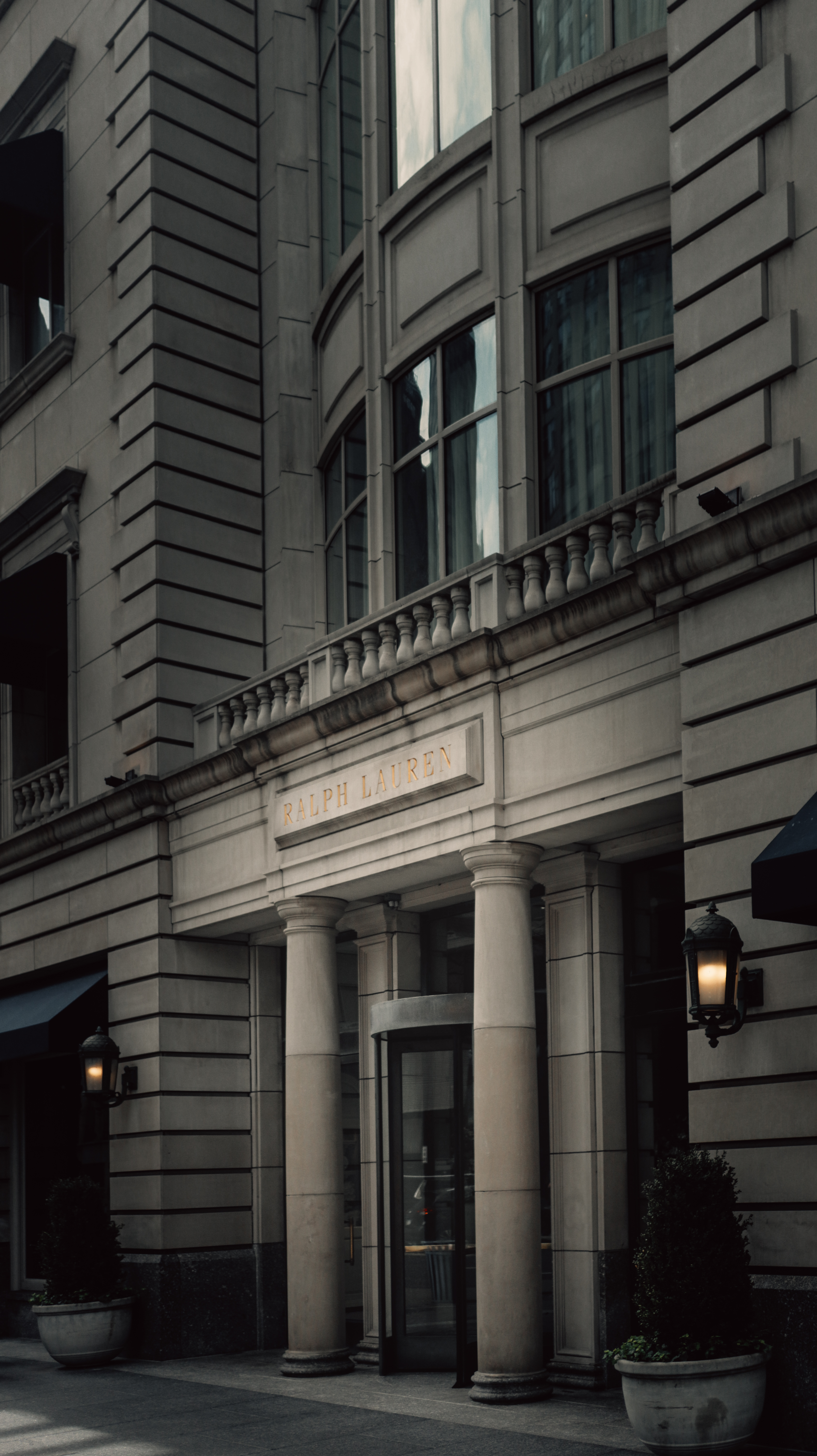 Ralph Lauren entrance at dusk — dark exterior, warm light spilling from awning